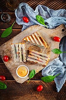 Club sandwich with ham, tomato, cheese and spinach. Grilled panini. Top view