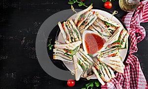 Club sandwich with ham, tomato, cucumber, cheese,  and arugula