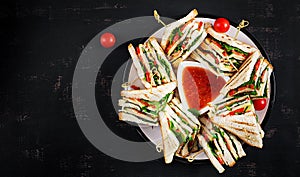 Club sandwich with ham, tomato, cucumber, cheese, and arugula