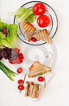 Club sandwich - panini with ham, cheese, tomato and herbs