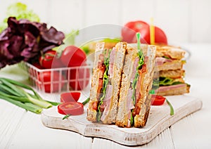 Club sandwich - panini with ham, cheese, tomato and herbs