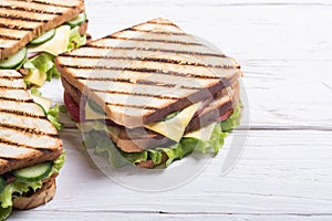 Club sandwich with tomatoes , cucumber , ham and cheese