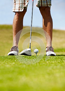 This club should do the trick.... Cropped image of a golfer about to smack the golfball down the fairway.