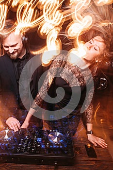 Clubbing, party, girl dancing with DJ at console