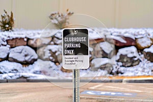 Clubhouse Parking Only signage with blurred rocky and snowy wall background