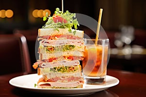 clubhouse sandwich miraculously balanced on a tall water glass