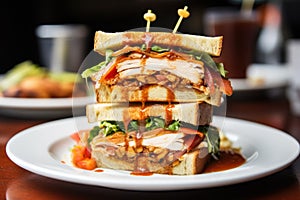 a clubhouse sandwich with plentiful sauces oozing out