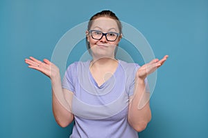 Clueless young caucasian woman in glasses shrugging helpless