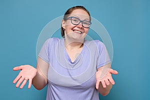 Clueless young caucasian woman in glasses shrugging helpless