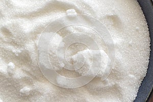 Clumped sugar in a bowl. White refined granulated sugar.
