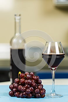 Cluster of red grapes and a glass of dry red wine