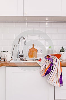 Clutter, dirty dishes by the sink in the white kitchen