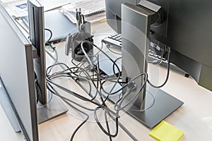 Clutter in office on the table. Unwound and tangled electrical computer wires. 5S system of lean manufacturing