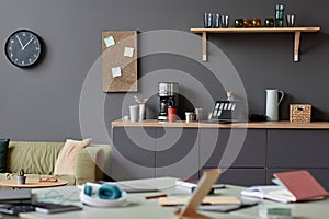 Cluttered office space in neutral grey with focus on coffee station