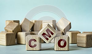 CMO - acronym on wooden cubes on a light background