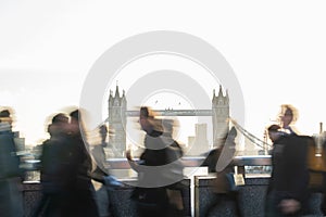 Motion Blur Shot Of Commuters Walking To Work Across London Bridge UK With Tower Bridge In Background