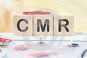 CMR Contract Management Review or Clear Motion Rate signs on wooden cubes on a light background