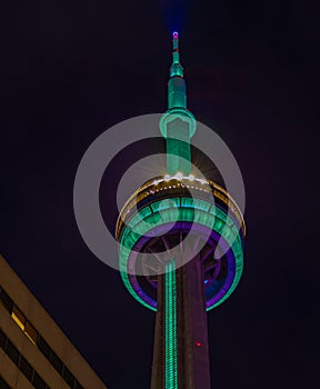 Close up top of CN tower at night. Smudgy clouds.