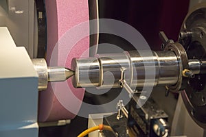 The CNC cylindrical grinding machine with the steel shaft.