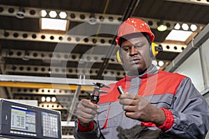 CNC Machine Operator In Protective Workwear Checking Measurements With Vernier Caliper