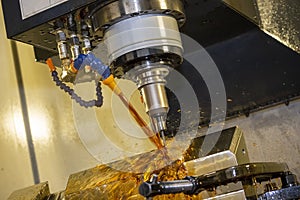 The CNC milling machine cutting the tire mold parts with liquid oil coolant method in vertical scene.