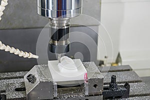 The CNC milling machine hi-precision cutting the plastic parts by solid ball endmill tool. photo