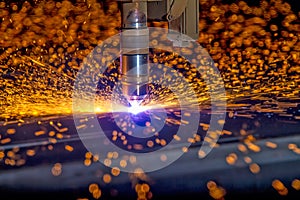 CNC Plasma torch cutting steelplate with orange bokeh sparks photo