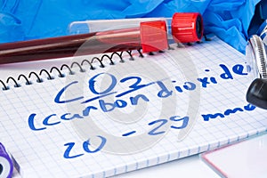 CO2 or carbon dioxide in serum or blood in basic metabolic test. Laboratory test tubes with blood smear, stethoscope or film and g