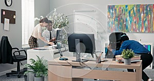 Co-workers elegantly dressed sitting in the office in the corporation, cheerful work, funny atmosphere, friends throwing
