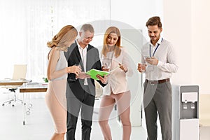 Co-workers having meeting near water cooler