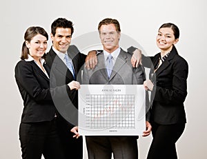 Co-workers holding financial line graph