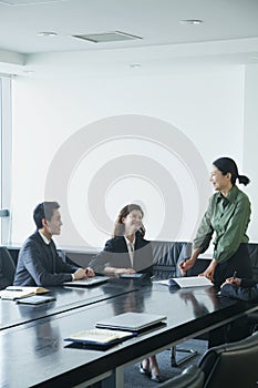 Co-workers in meeting room, discussing