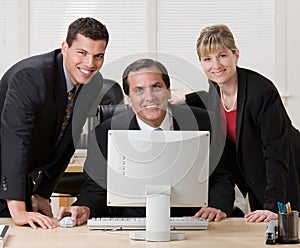 Co-workers posing together at desk