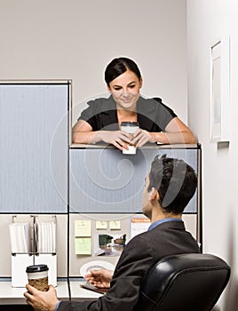 Co-workers talking in office cubicle photo