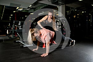 The coach controls the push-up technique of her ward