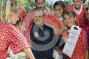 Coach Discussing Strategy With Girls Soccer Team