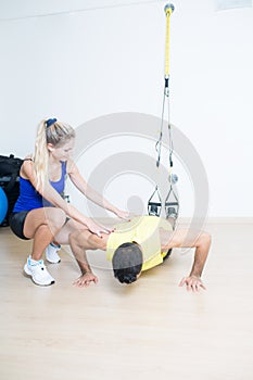 Coach helping with suspension training