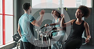 Coach, high five or people on cycling machine for a biking workout or cardio training for endurance. Fitness class, gym