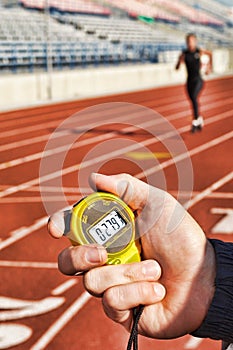 Coach holding Stopwatch Timing Runner