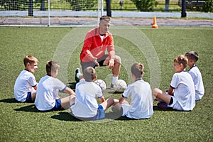 Coach Instructing Junior Football Team in Practice