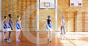 Coach mentoring high school kids In basketball court 4k