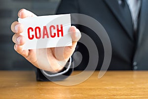Coach, message on white card and hold by