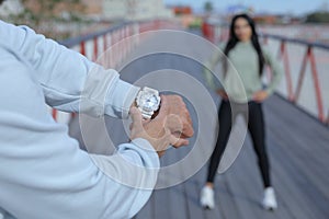 The coach`s male hand points to the watch before starting a workout
