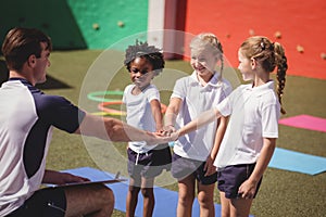 Coach and schoolkids forming handstack