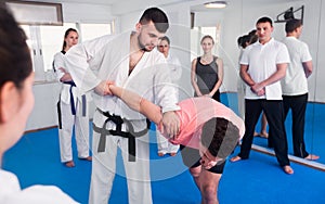 Coach showing new submission hold in taekwondo class