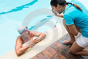 Coach showing stopwatch to senior man