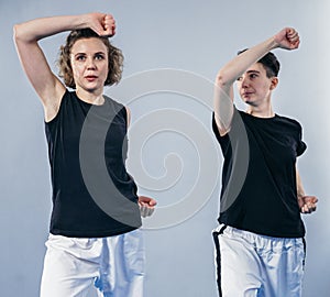 Coach teaches athlete to hit kick. Strong female martial arts athletes in their taekwon-do training. Two young women instructor