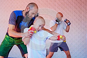 The coach teaches the boy kick Boxing