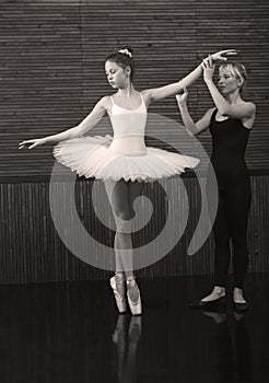 The coach teaches a small ballerina