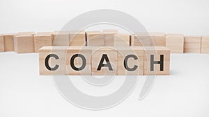 COACH word, text, written on wooden cubes, building blocks, over white background